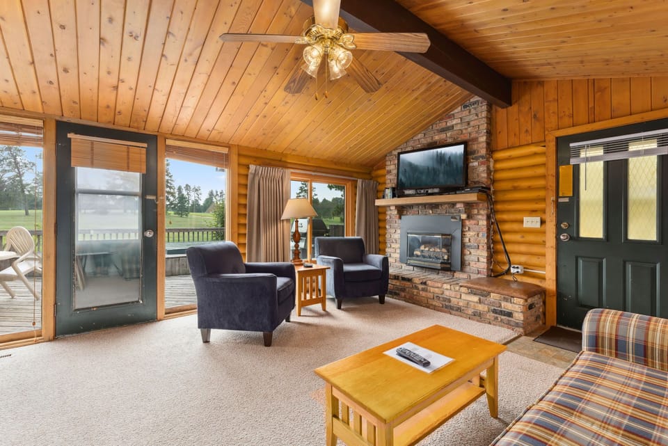 The inviting living space features rustic log walls and a cozy fireplace, perfect for family gatherings after a day of outdoor adventures.