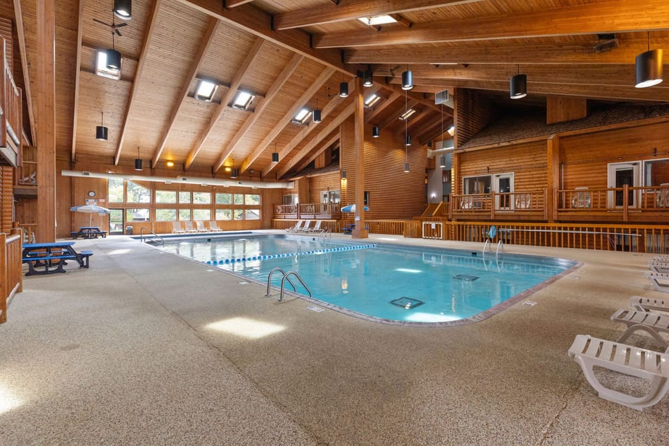 Expansive indoor pool area with lounge seating and vaulted ceilings.