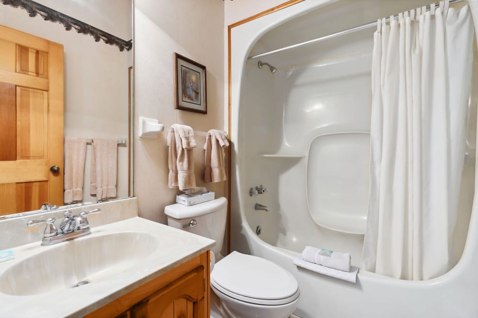 Bright bathroom with walk-in shower and large vanity mirror.