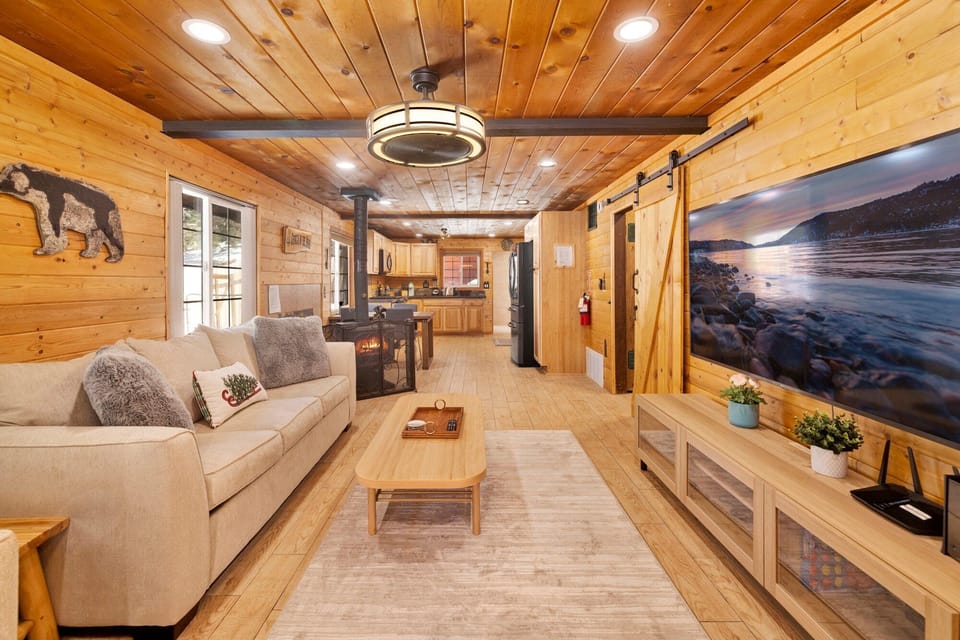 Cozy mountain living room with a fireplace, comfy seating, and smart TV, perfect for relaxing evenings, movie nights, and warm cabin vibes after outdoor adventures.