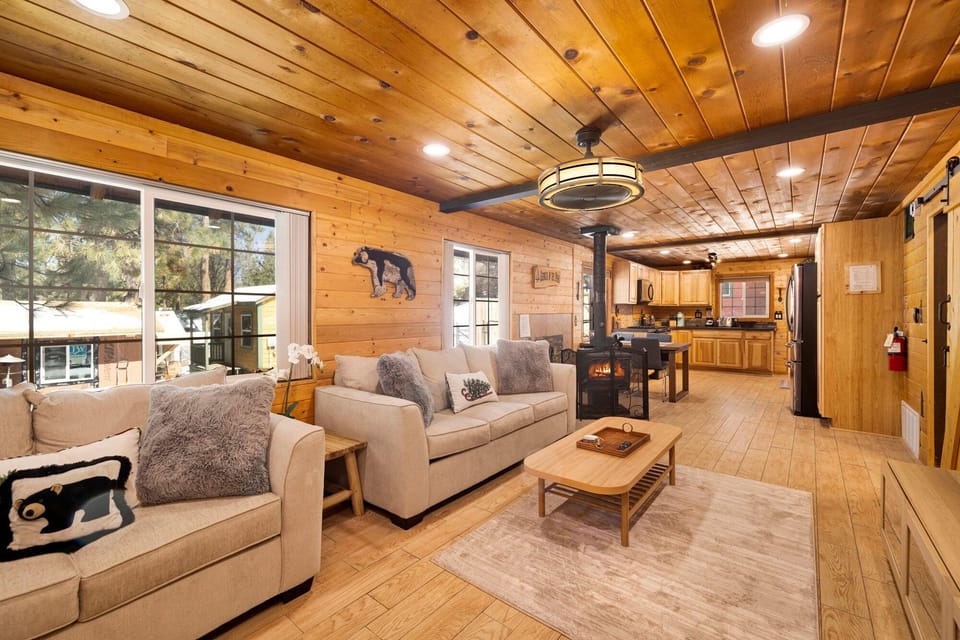 Cozy mountain living room with a fireplace, comfy seating, and smart TV, perfect for relaxing evenings, movie nights, and warm cabin vibes after outdoor adventures.