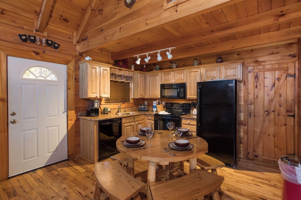 dining table with bench seating for four at always & forever a 1 bedroom cabin rental located in pigeon forge