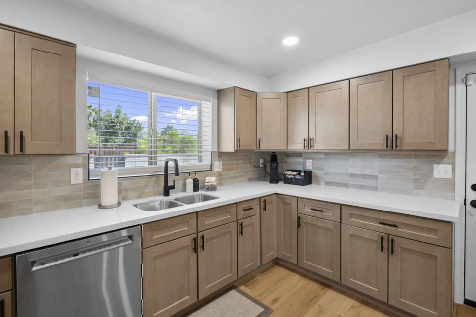 Bright corner kitchen w/ wraparound counters, warm wood cabinets & plenty of space to prep meals.