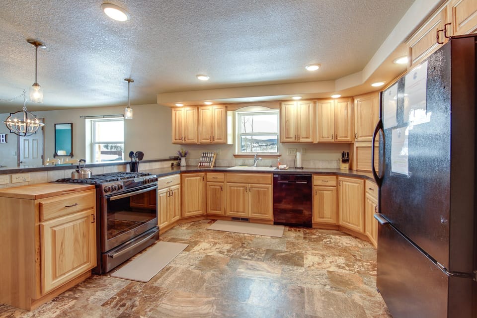 Spacious kitchen with gas stove, full fridge, and room for everyone to cook.