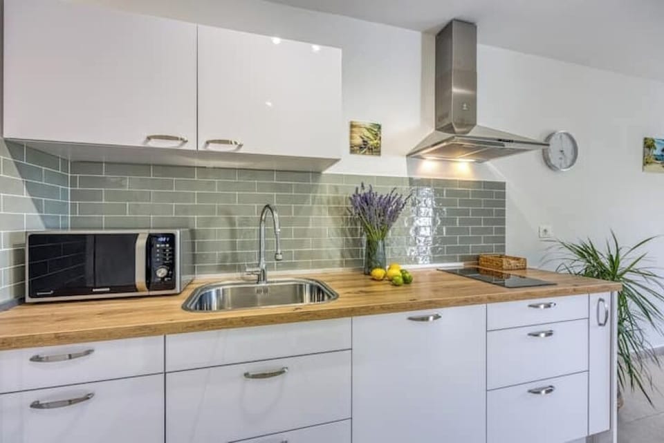 Kitchen equipped with espresso machine,  pop-up toaster, kettle and kitchenware.