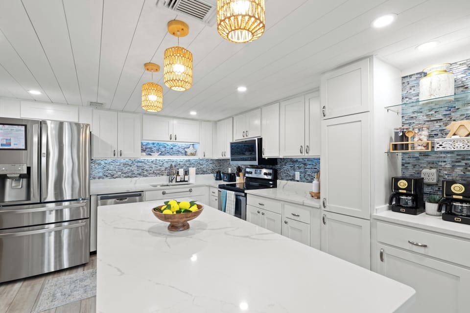 Fully stocked modern kitchen with stainless steel appliances and coffee maker