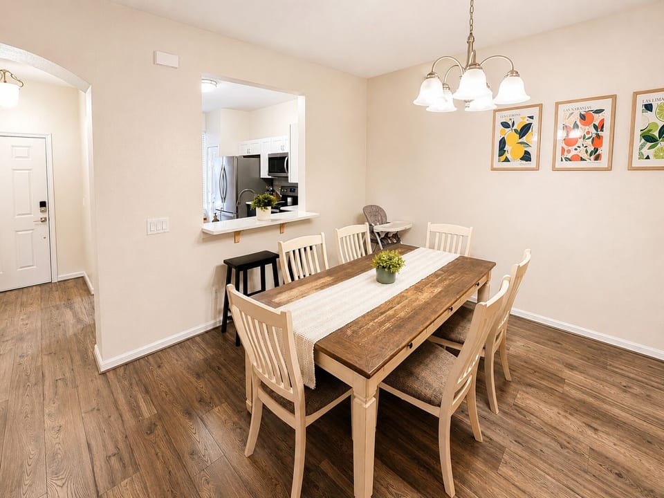 Bright dining area with seating for six, open access to the kitchen, and a welcoming layout for family meals, game nights, and relaxing together after a day at the parks.