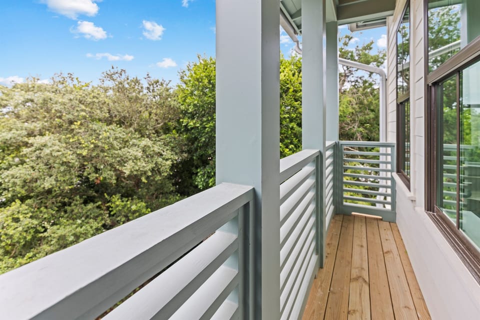 Step onto your private balcony and breathe in the fresh air while overlooking lush green treetops and blue skies.