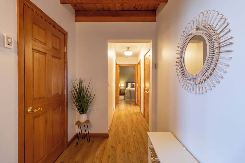 Hallway leading to primary suite, second upstairs bedroom and guest bathroom