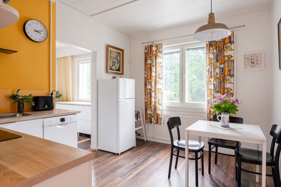 Open-concept living and dining area with contemporary Nordic decor and a warm, inviting atmosphere.