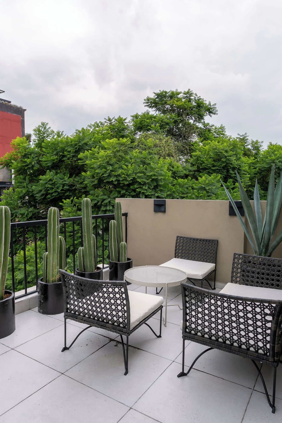Terraza común ubicada en quinto piso con sillas de exterior y vista al ciudad