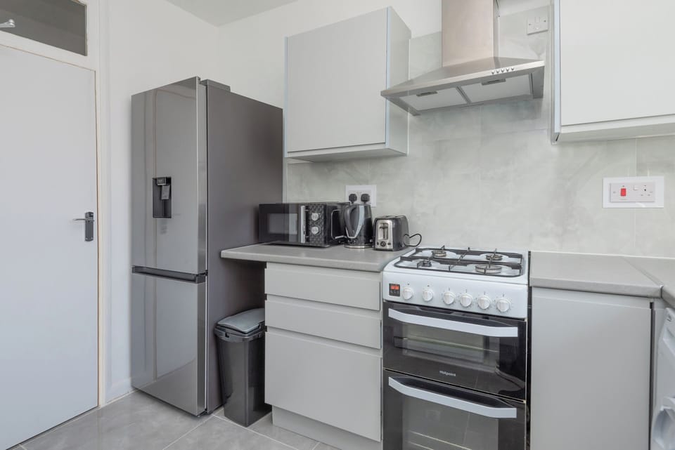 Chef’s kitchen with fridge, gas stove, double oven, microwave & kettle.