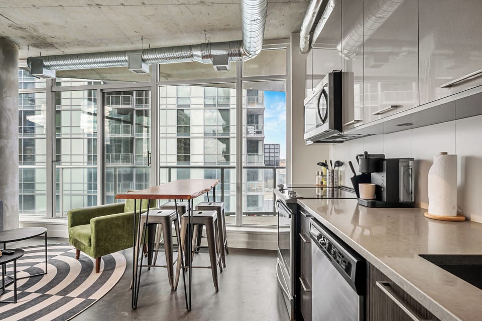 Open-concept kitchen and breakfast bar framed by expansive windows — a perfect spot to start your day.