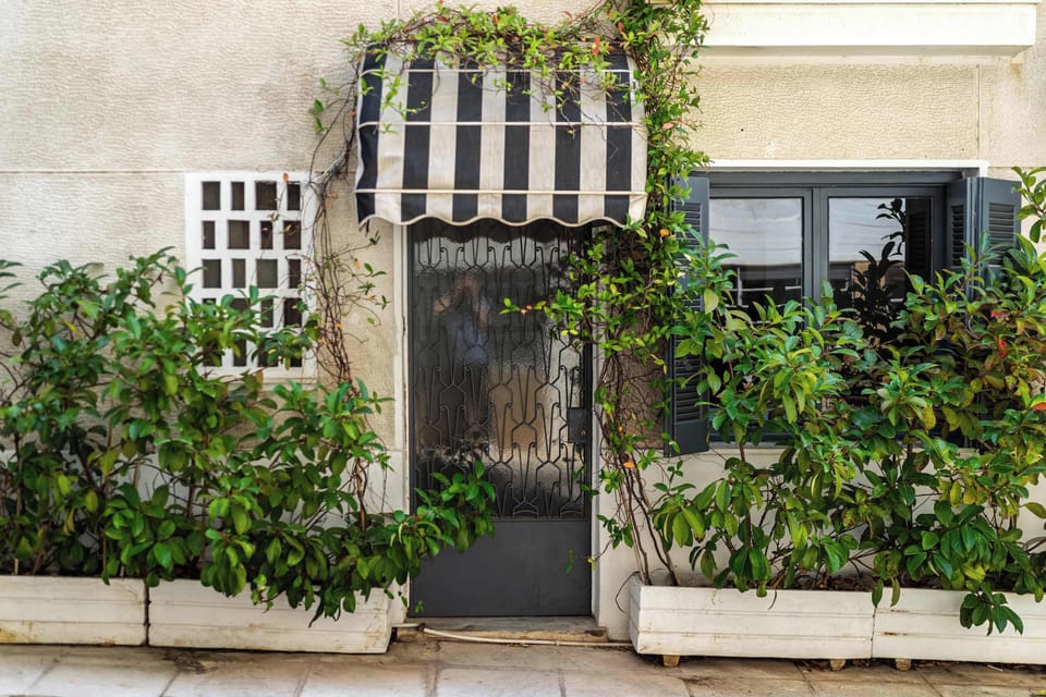 Charming ground-floor entrance with striped awning, making the apartment easy to locate.