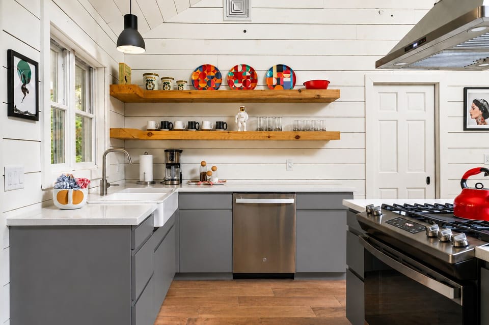 Load the dishwasher after dinner and grab mugs or glasses right off the open shelves. The farmhouse sink and stove give you everything you need to cook and clean up.