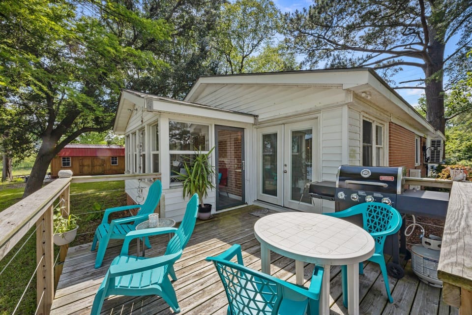 Back deck with grill, cozy table & colorful chairs, linked to sun porch.
