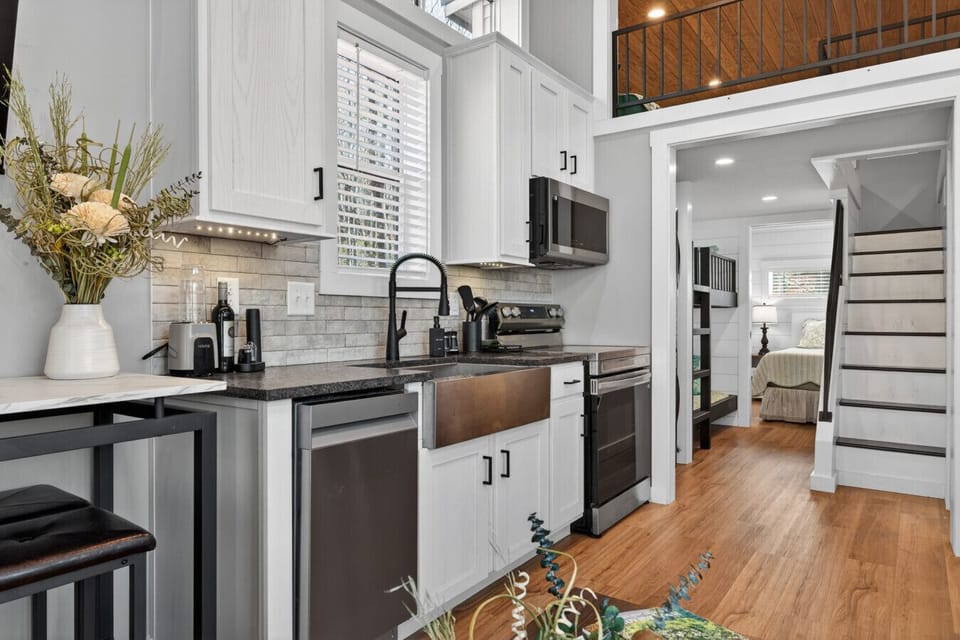 Bright, modern, and thoughtfully designed, the kitchen features a dishwasher, microwave, stove, and full size refrigerator.