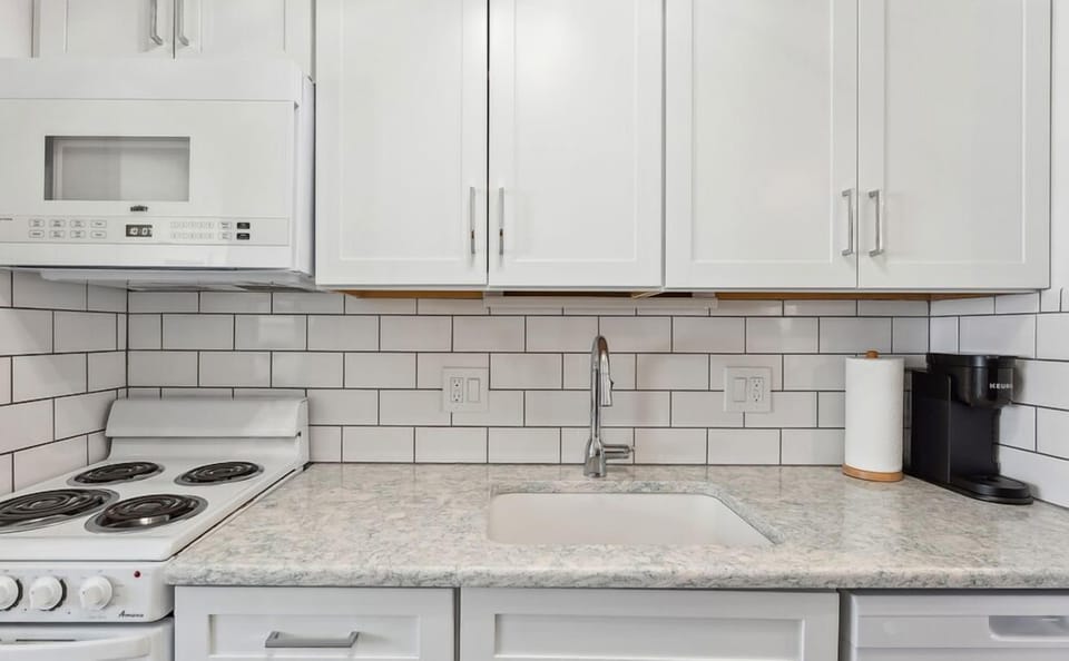 Well-equipped kitchen with stovetop, fridge, microwave, and Keurig

