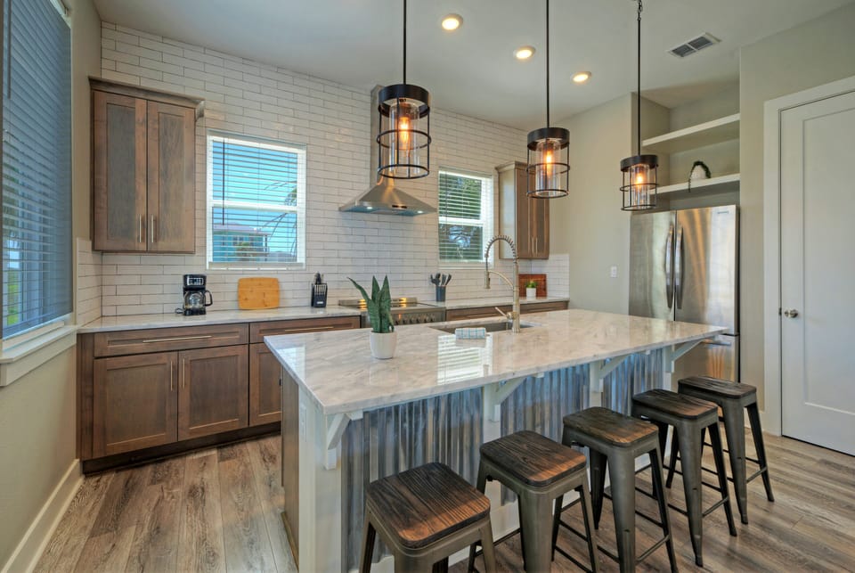 Modern kitchen with island seating and pendant lighting.