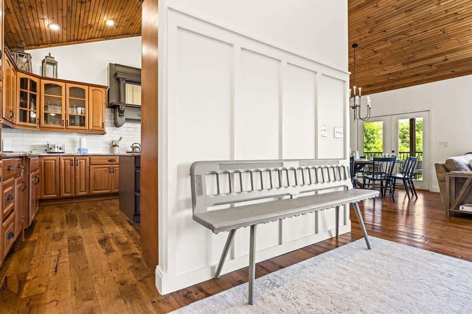 Clean, airy entryway with wood ceilings and natural light leading into a cozy living area with mountain views.