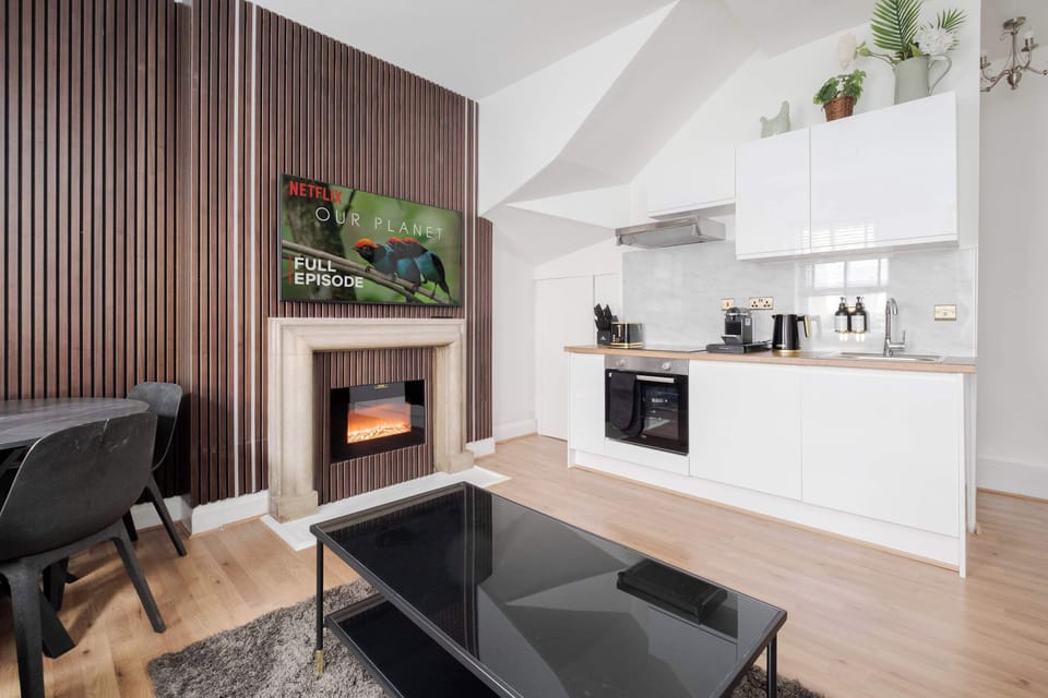 Living Room | Unwind in a beautifully designed living room featuring elegant wooden panels and ambient LED lighting. This serene sanctuary includes a 60-inch smart TV, thoughtfully arranged for your ultimate comfort.