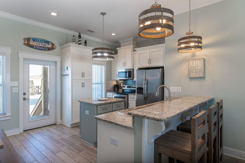 Your fully equipped kitchen awaits with granite counters, modern appliances, and coastal charm for memorable meal prep.