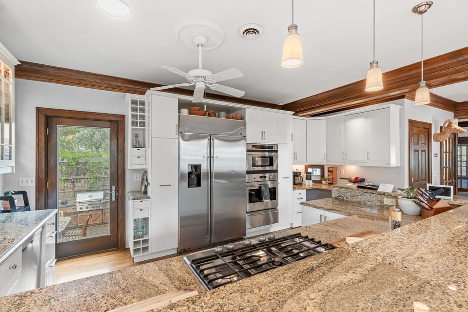 Your gourmet kitchen awaits with granite counters, stainless appliances, and warm pendant lighting—perfect for preparing memorable meals together.