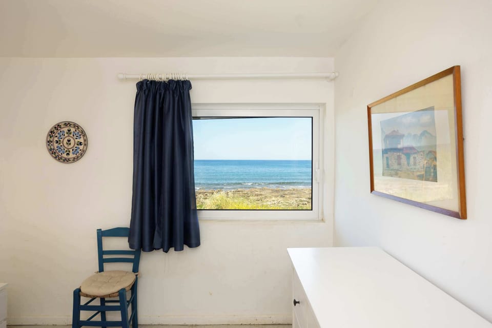 Bedroom with Sea-Inspired Decor – Features a writing desk and framed art.

