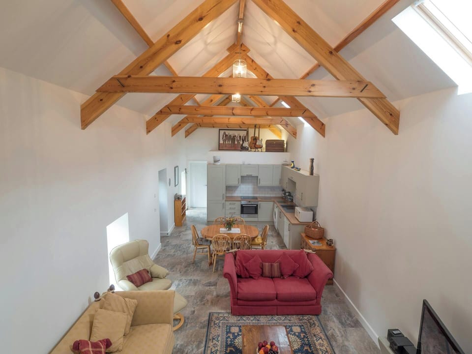 Ceiling beams, sofas, TV, kitchen and dining area from the Mezzanine
