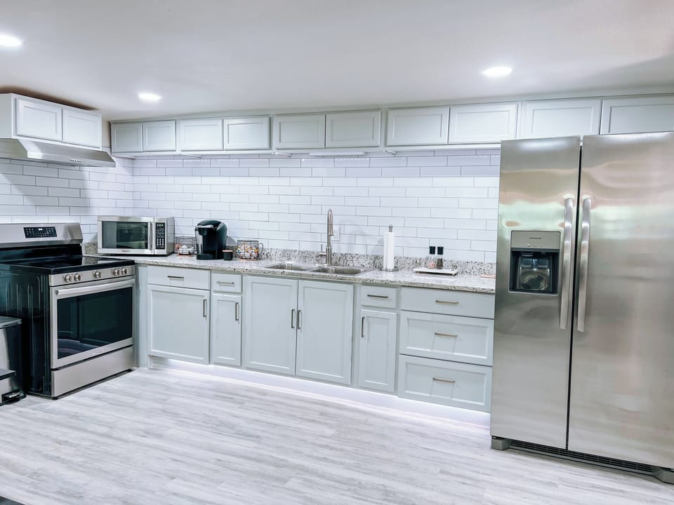 This kitchen has new appliances and is fully equipped with cooking utensils. 