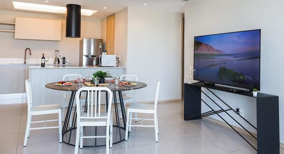 Dining table for shared meals beside the living area & TV, creating an easy open flow