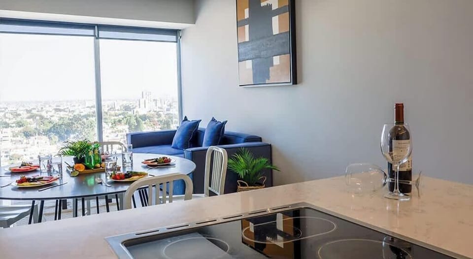 Sleek kitchen counter w/ bar seating, sink & open views to the living area