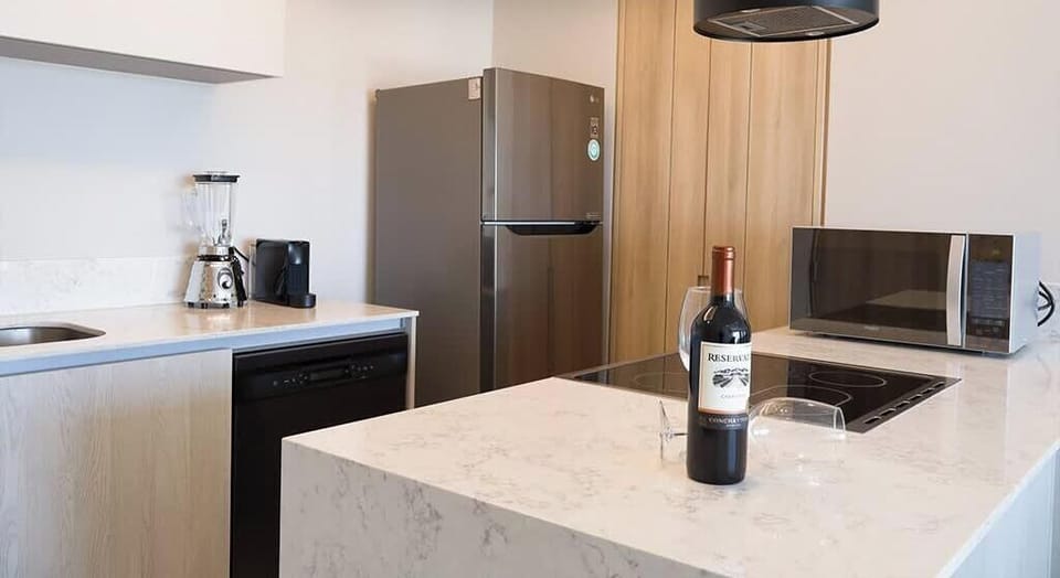 Contemporary kitchen w/ island seating, fridge & stylish wood cabinetry