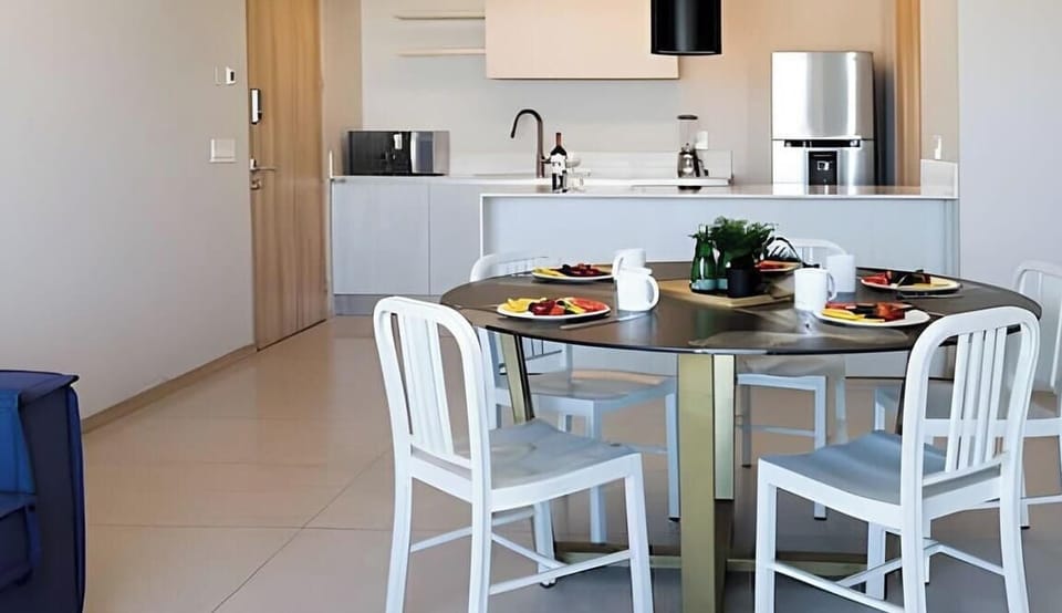 Bright dining nook w/ table set for meals beside the open kitchen