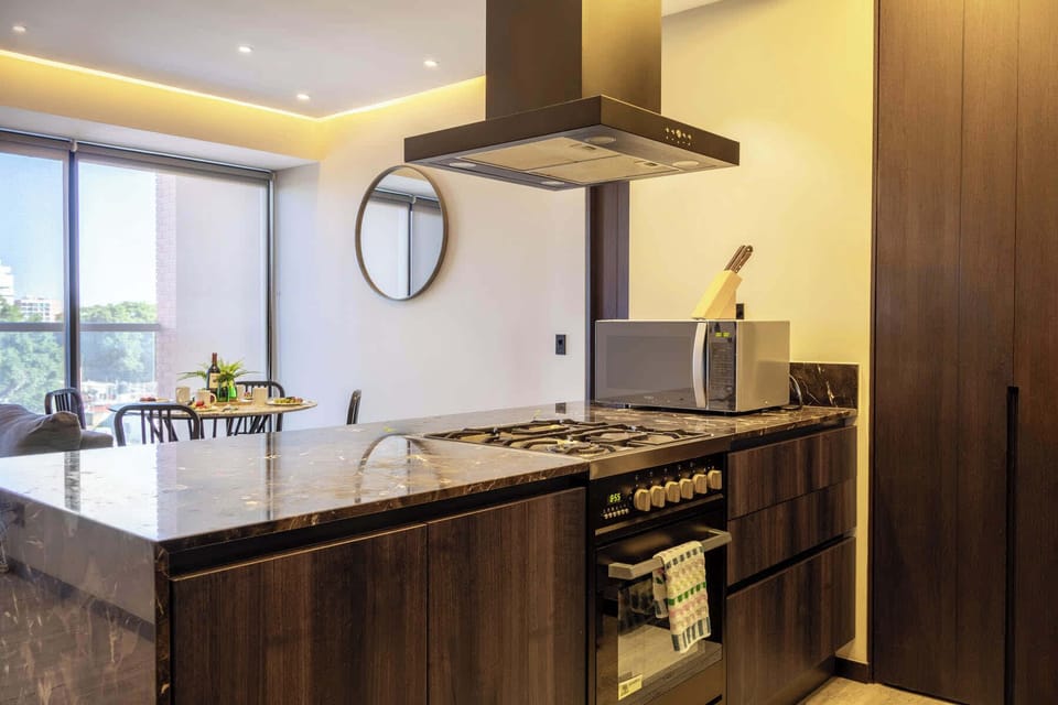 Contemporary kitchen w/ wood cabinetry, sleek counters & modern appliances