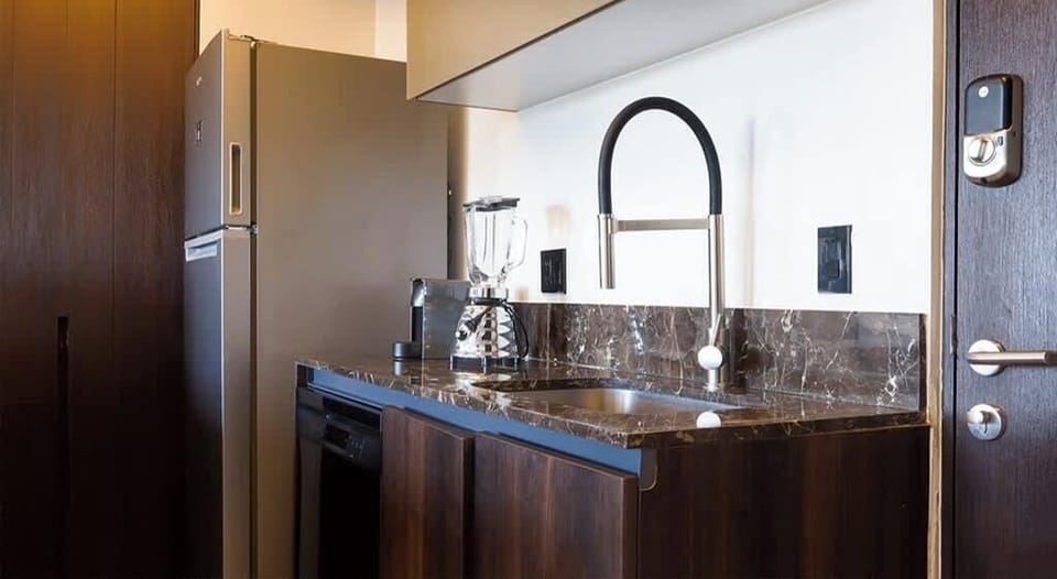 Modern kitchen w/ sleek counters, sink & warm wood cabinetry