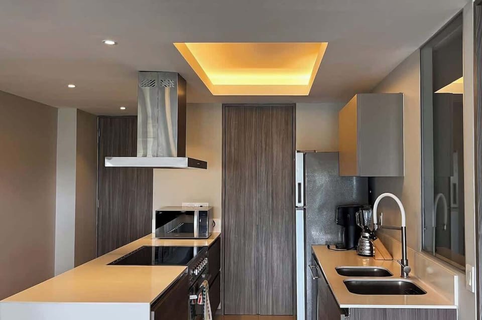 Sleek kitchen w/ long island, bar seating & warm recessed lighting