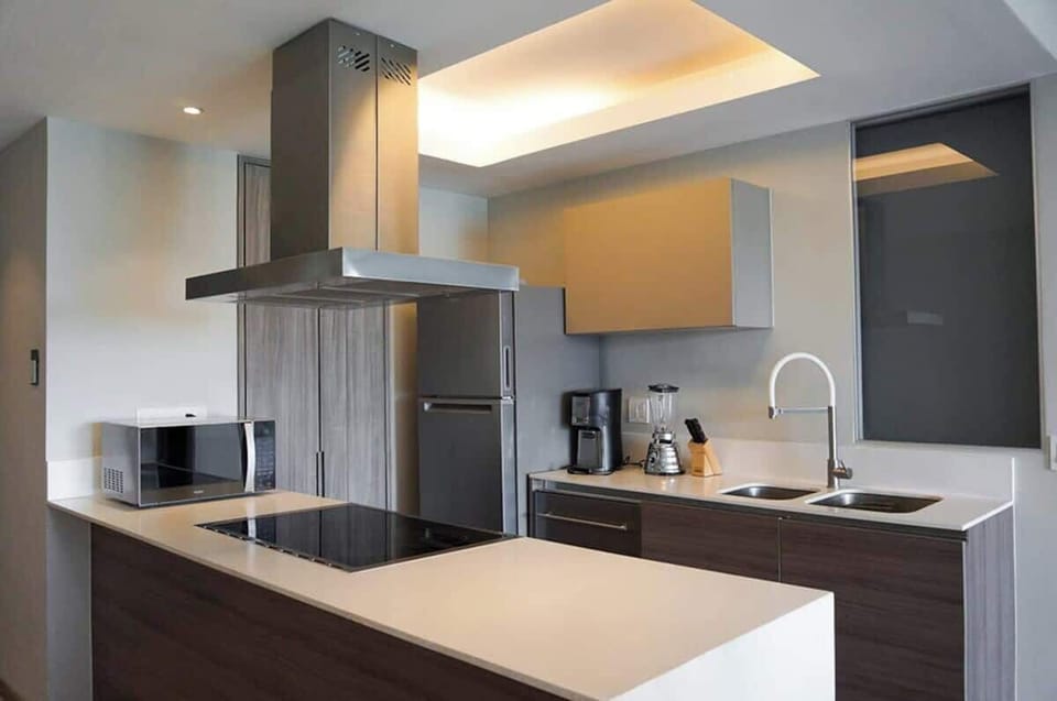 Modern kitchen w/ sleek cabinetry, island seating & stainless appliances