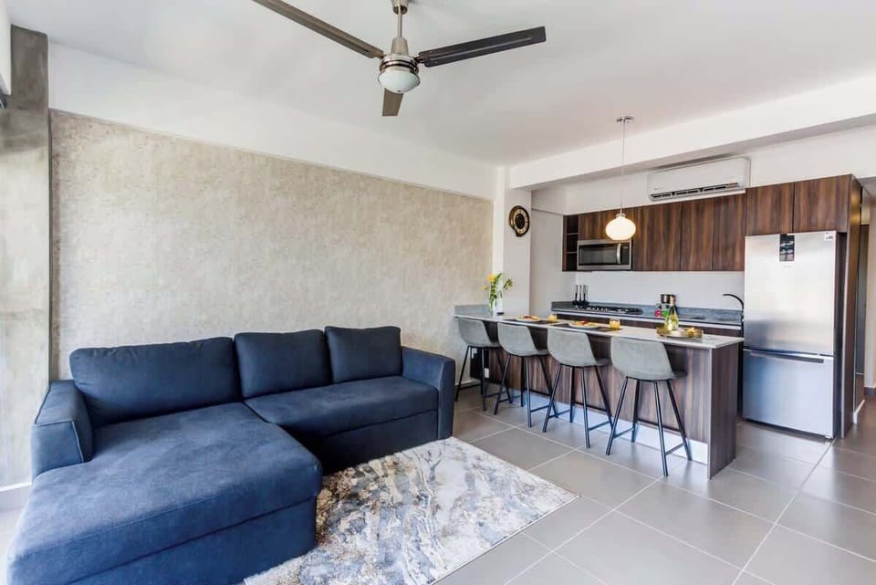Open living space w/ sectional sofa flowing into a modern kitchen & dining area