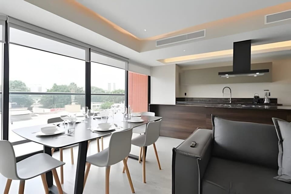 Open living & dining area w/ large windows, island seating & city views