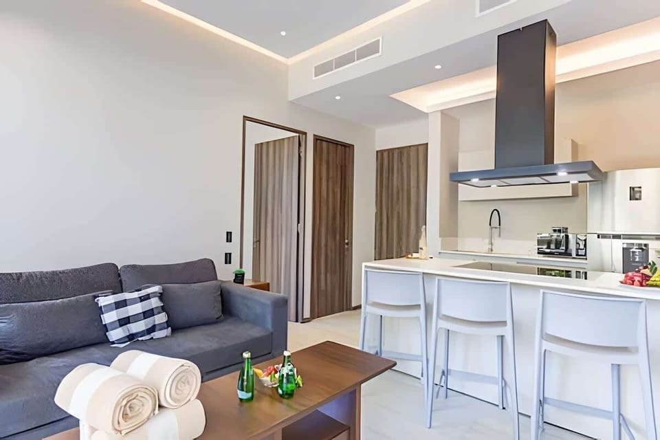 Open living space flowing from lounge to kitchen island w/ bar seating