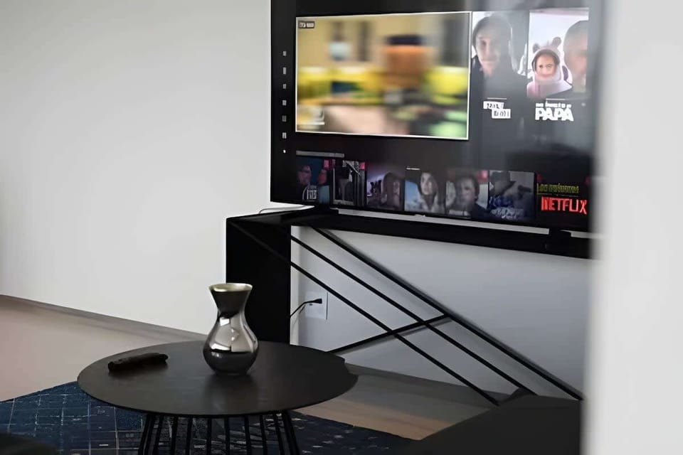 Cozy media nook w/ wall-mounted TV & small table for relaxed movie nights