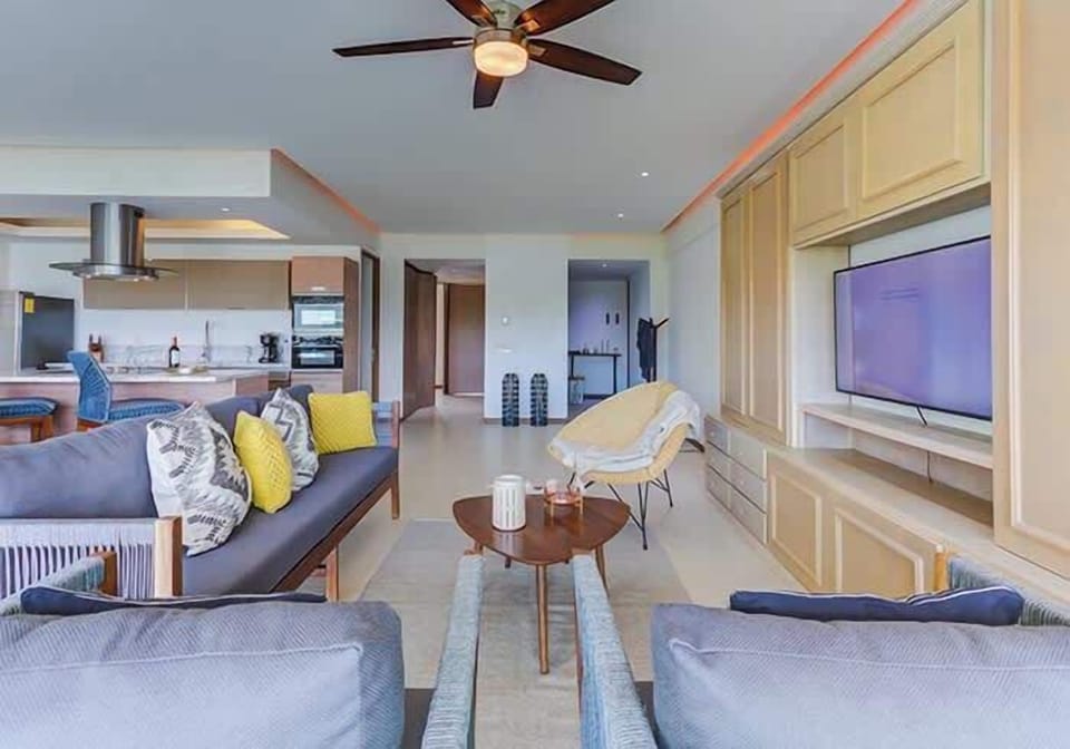 Inviting living space w/ comfy sofas, ceiling fan & natural light filling the room
