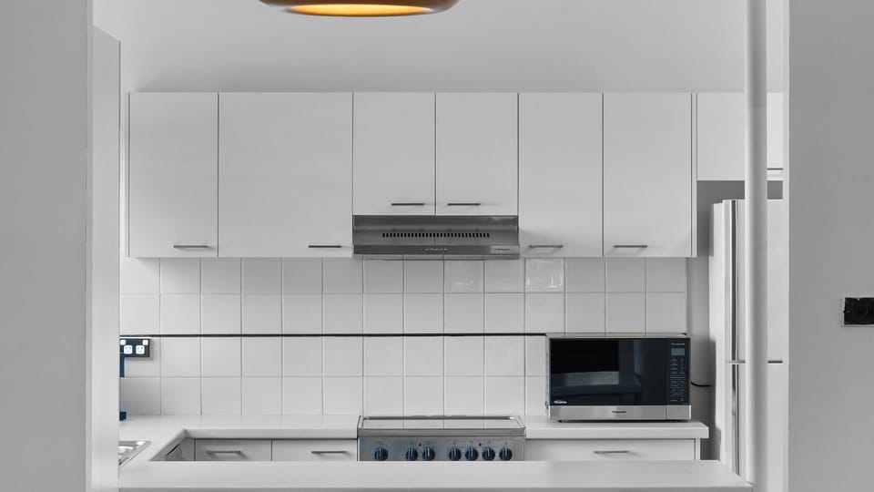 A fully equipped, crisp white kitchen ready for your inner chef!