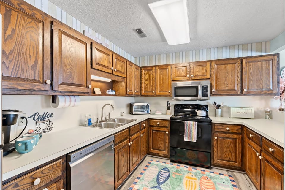 Cook in a fully equipped kitchen with warm wood cabinets and modern appliances.