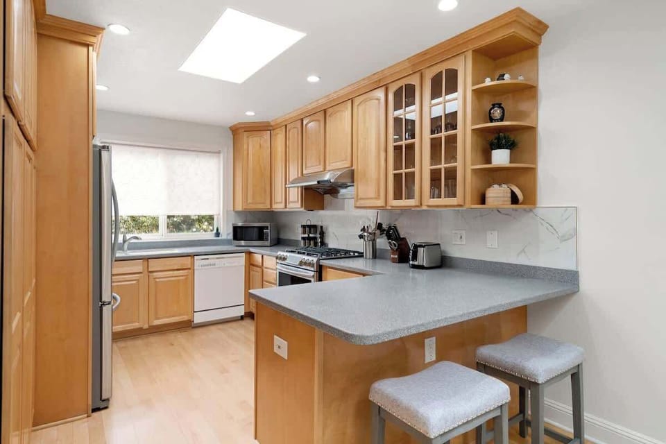 Kitchen with counter top equipped with cooking basics, dishes and silverware