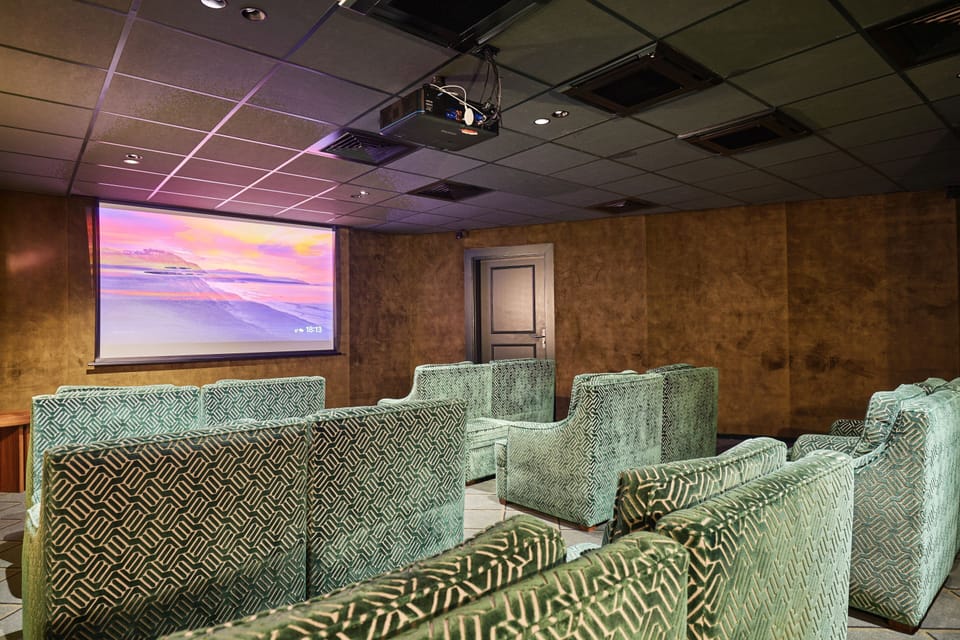 Cozy cinema room with plush chairs and large screen, ideal for movie nights indoors.