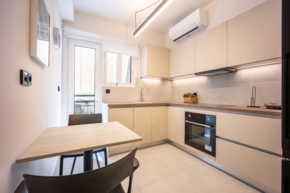 Streamlined cabinetry, natural light, and cozy dining corner blend functionality with contemporary sophistication