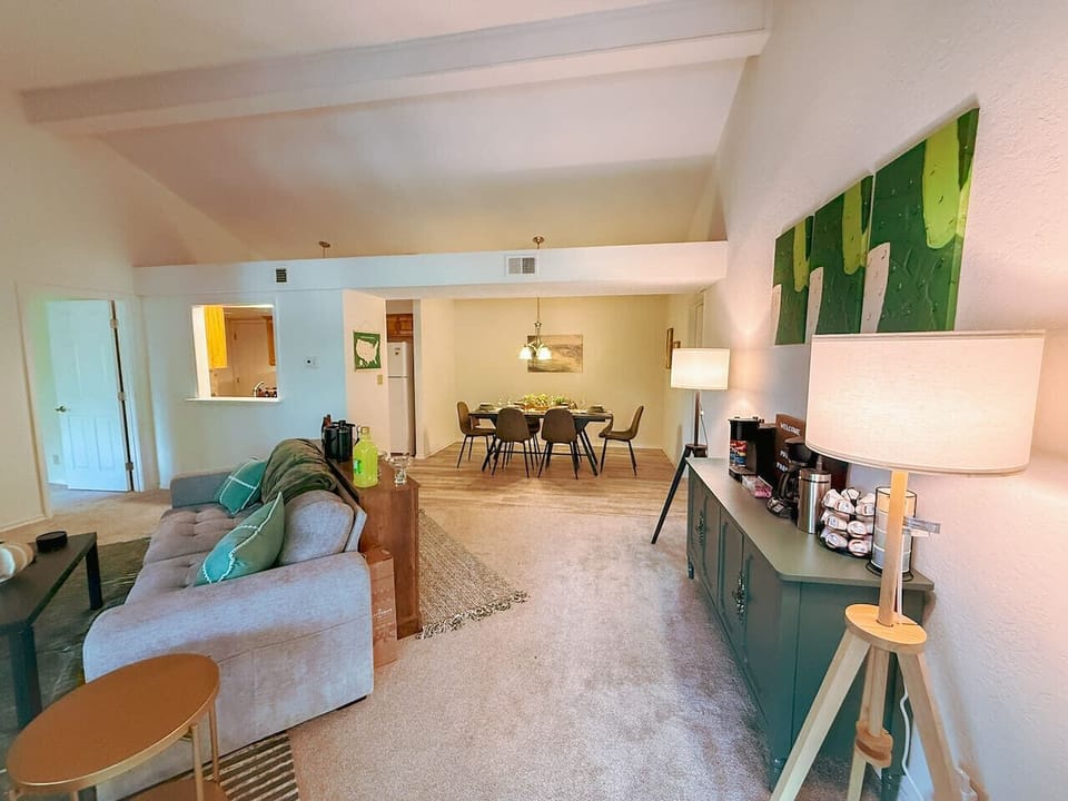 This spacious apartment boasts an open layout, seamlessly connecting the living room and dining area, ideal for both relaxation and entertaining. Vaulted ceilings and large windows create an airy atmosphere, while a dedicated coffee bar adds convenie