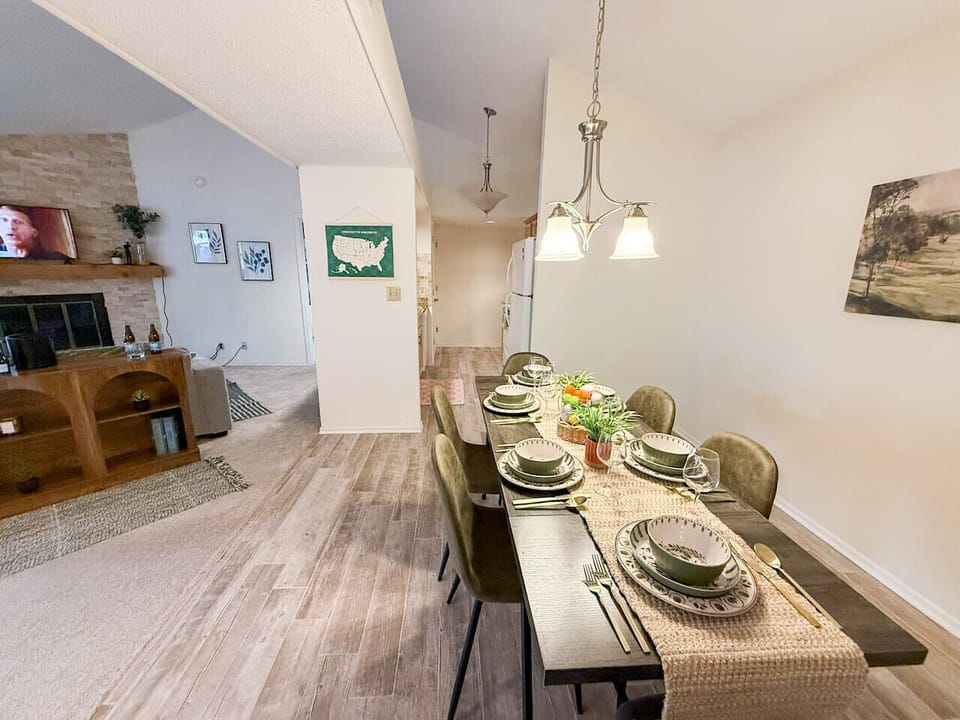 This inviting open-concept space features a well-appointed dining area with ample seating, flowing seamlessly into a cozy living room, perfect for entertaining. Enjoy the bright and airy feel, complemented by attractive wood-look flooring and a charm